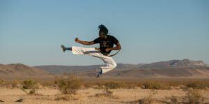 Person jumps high and strikes a pose in the Mojave Desert. This image comes from Mountainfilm on Tour.