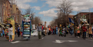 People of all ages and in costumes marching in a parade