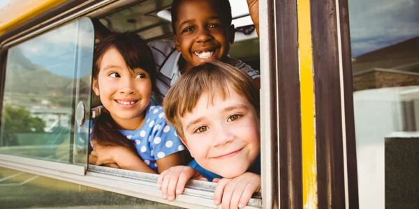 Kids smiling in school bus window