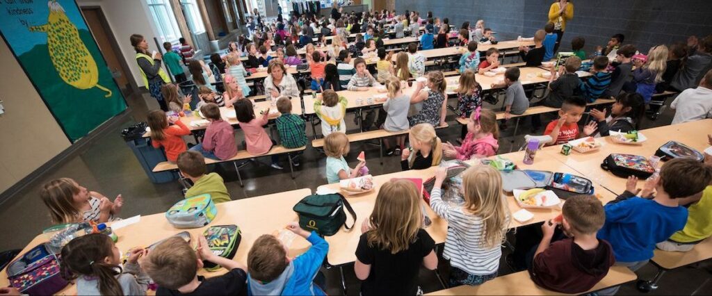 Students and adults at an event in a school cafeteria