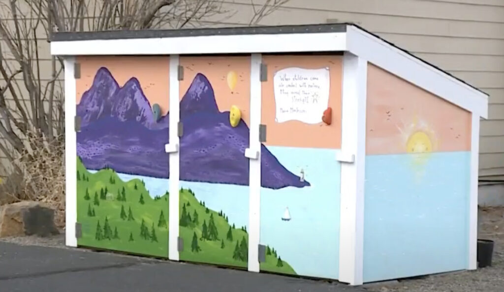 A small wooden hut painted with a landscape mural