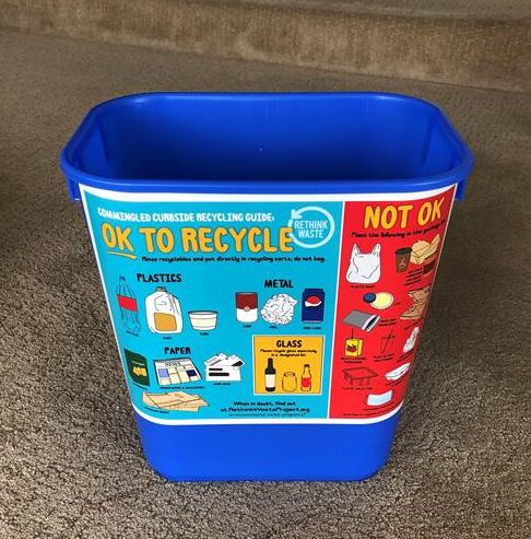 A blue household recycling bin with a clear sign of what to and not to recycle