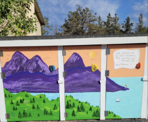 A small recycling hut with a mural depicting mountains, forest, and a body of water