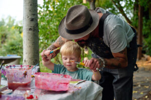 artist helping a young child paint
