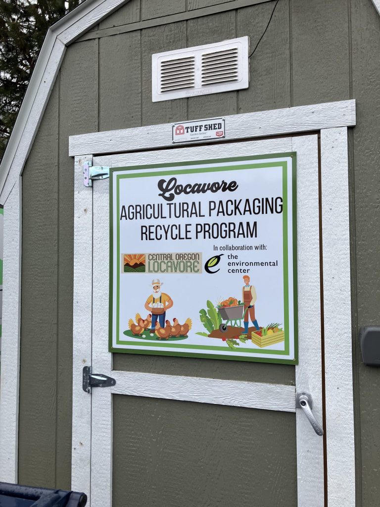 A storage shed with a sign that reads: "Locavore Agricultural Packaging Recycle Program in collaboration with The Environmental Center"