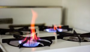 four burner gas stove with flames emenating from two burners