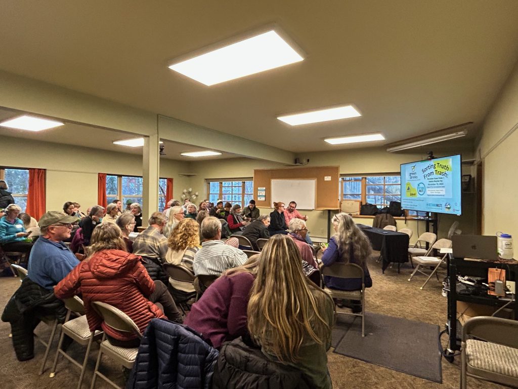 A pic of seated attendees in a room with presentation slide reading Sorting Truth from Trash