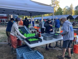 Folks at a waste sorting and dishwashing station under a canopy