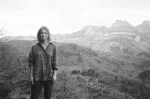 black and white photo of emma standing in front of mountains