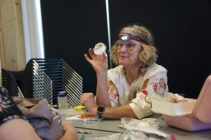 person with headlamp holding repair tools