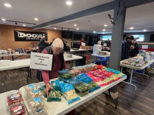 Older person reaching for package food from a smoargasbard on table
