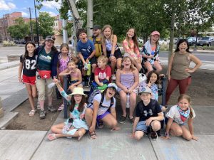 variety of children tall and short, plus several adults smiling in a large group photo