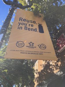 A banner that says "Reuse, you're in Bend" with a reusable water bottle graphic next to it