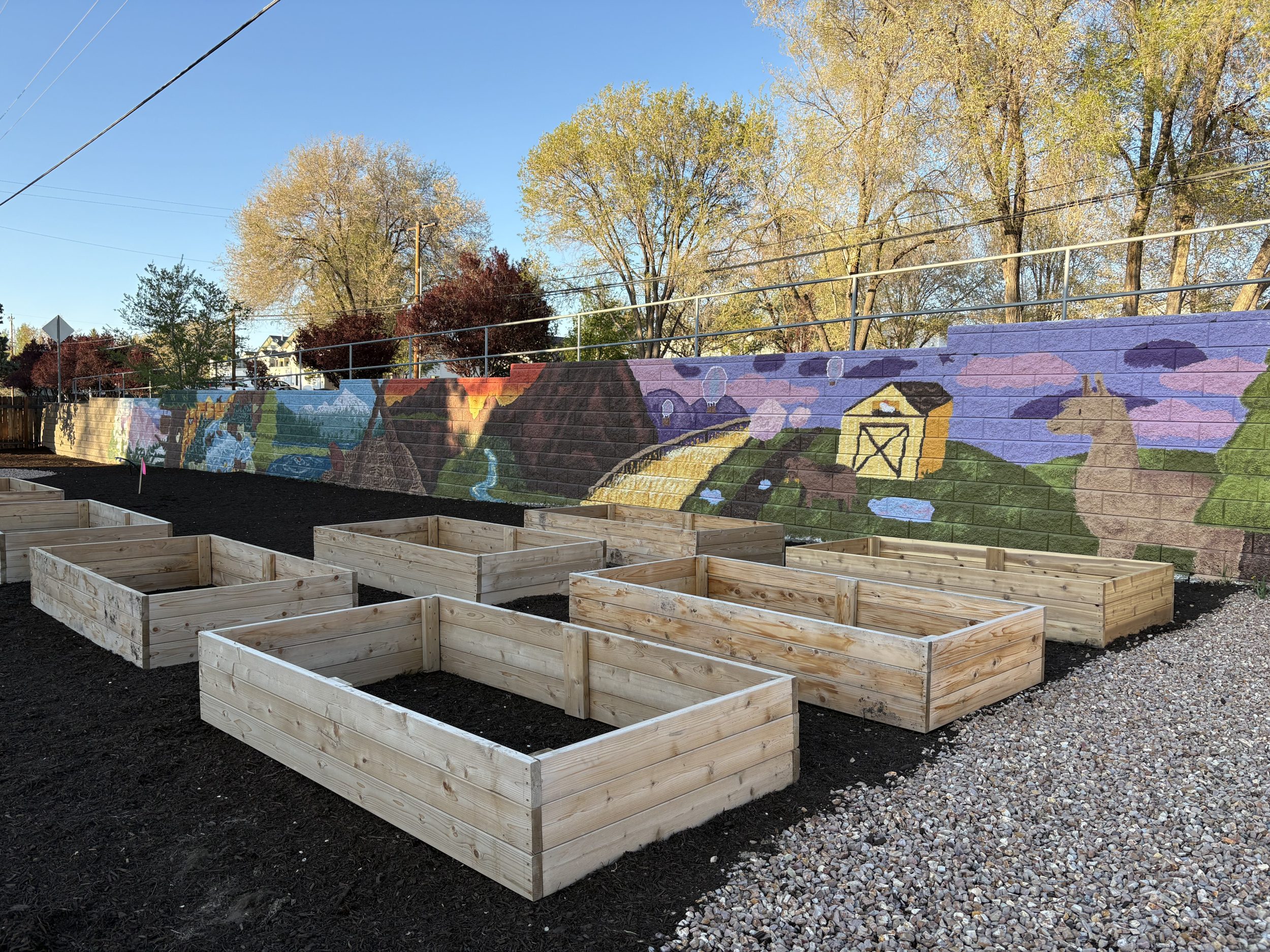 Garden beds in front of a mural.