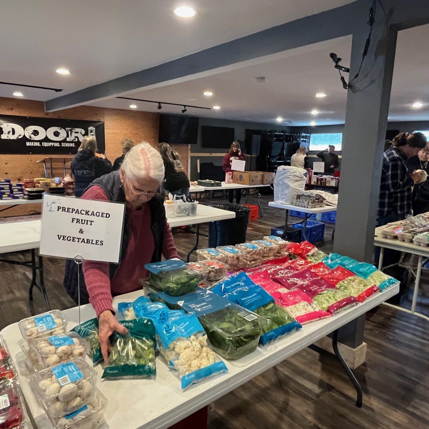 Older person reaching for package food from a smoargasbard on table